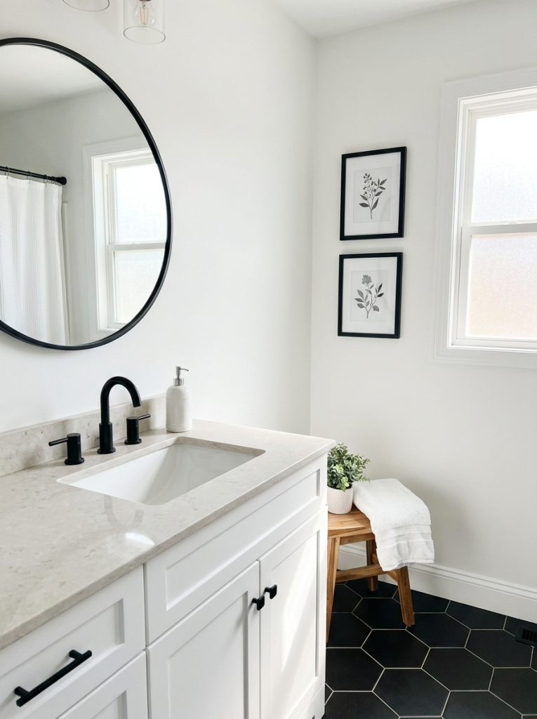 Black and white bathroom aesthetic with white walls black hex tiles black mirror white sink black faucet and black white botanical prints